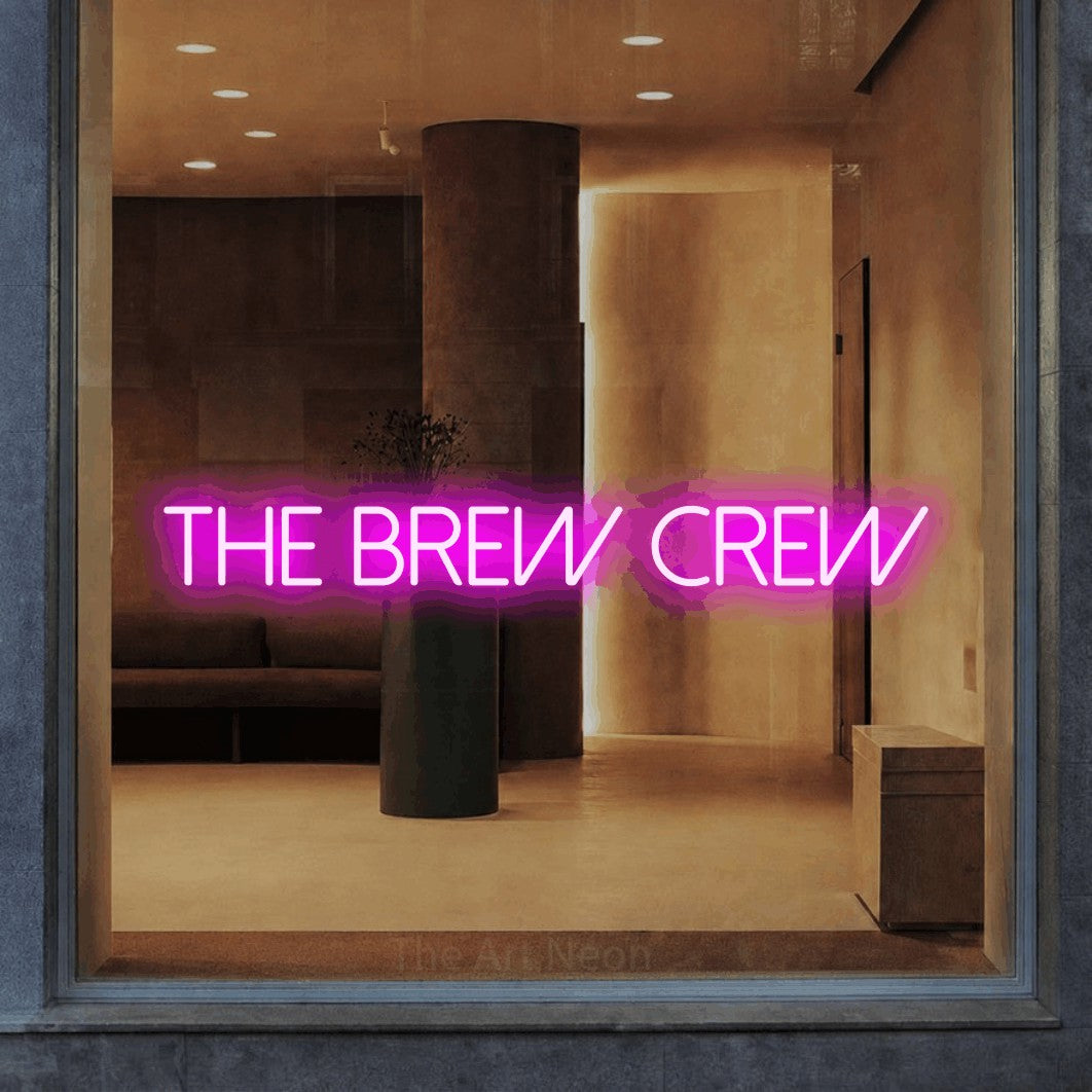 Pink LED neon sign reading "The Brew Crew" in a warm modern interior