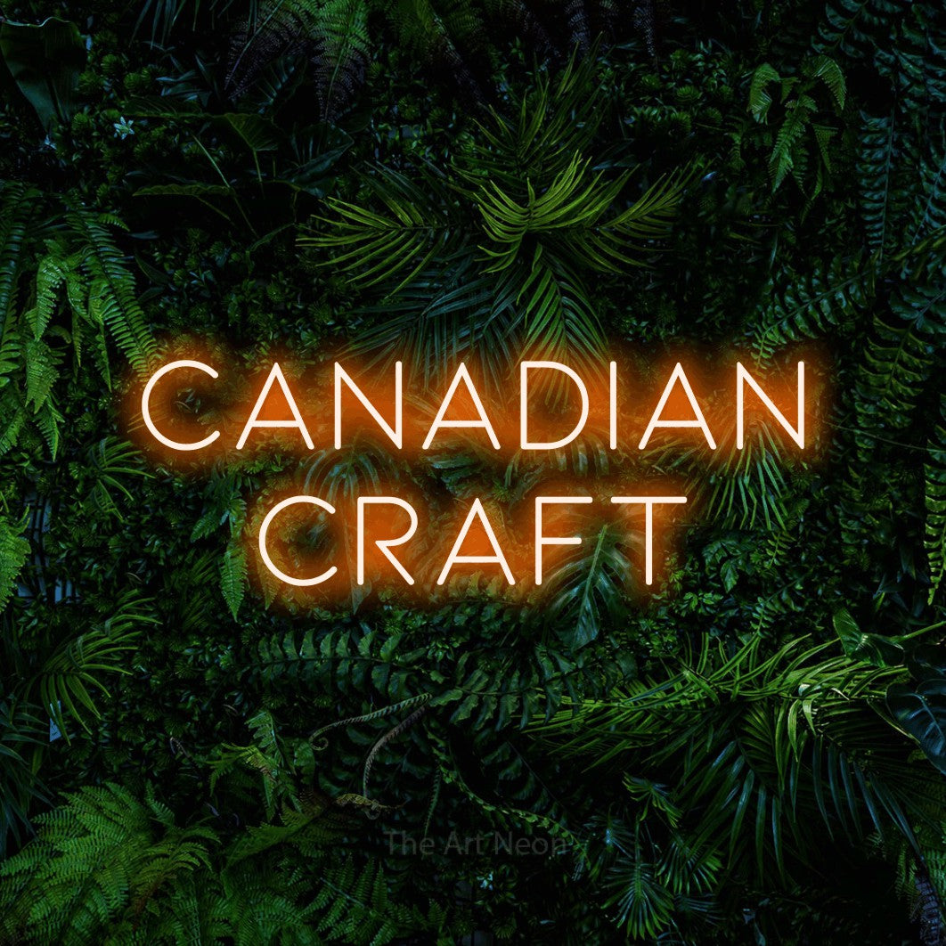 Orange LED neon sign reading "Canadian Craft" against a dense tropical foliage wall