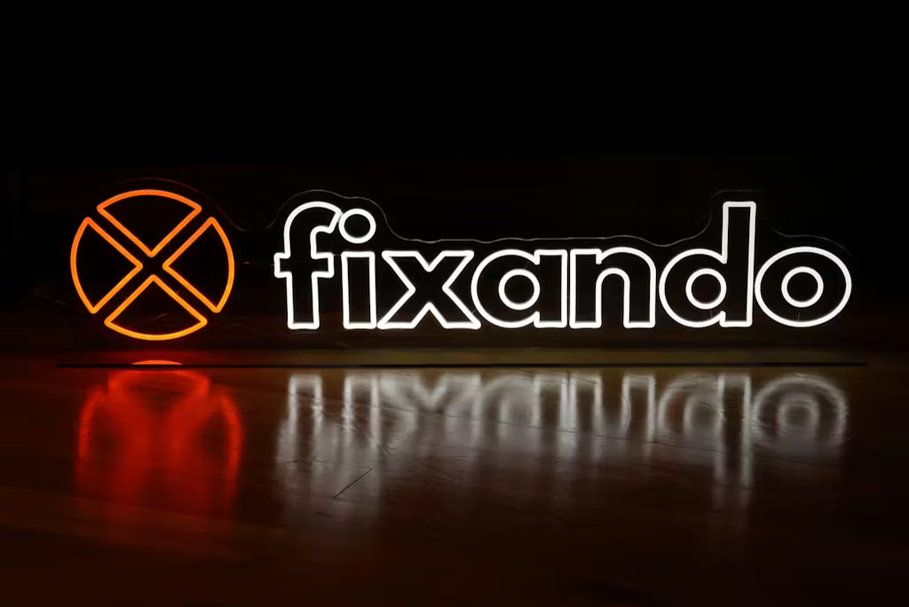Yellow icon and cool-white Fixando logo LED neon displayed on clear acrylic at a Portuguese business event.