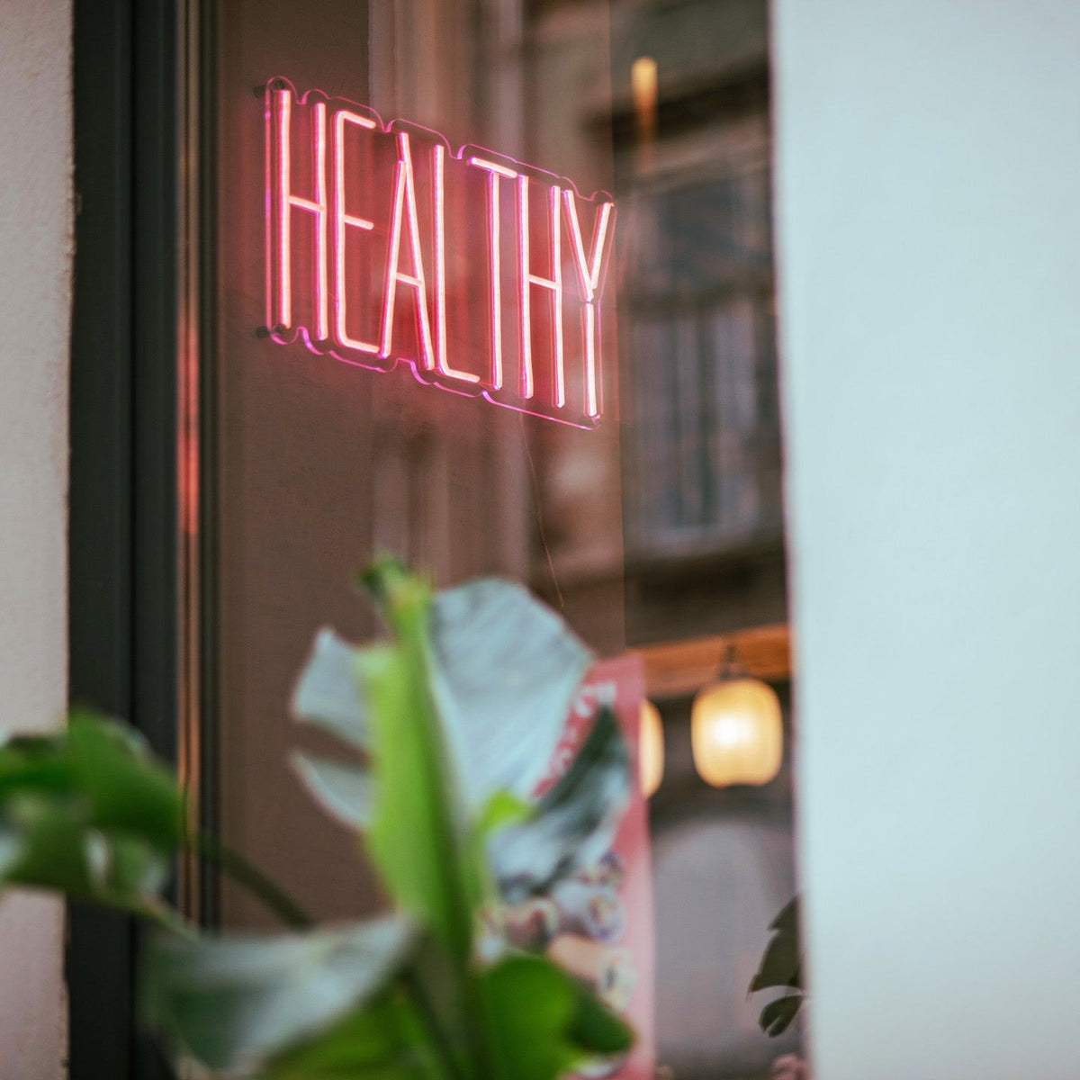 Pink vegan options LED neon sign on a wall inside Ichigo Budapest fusion restaurant.