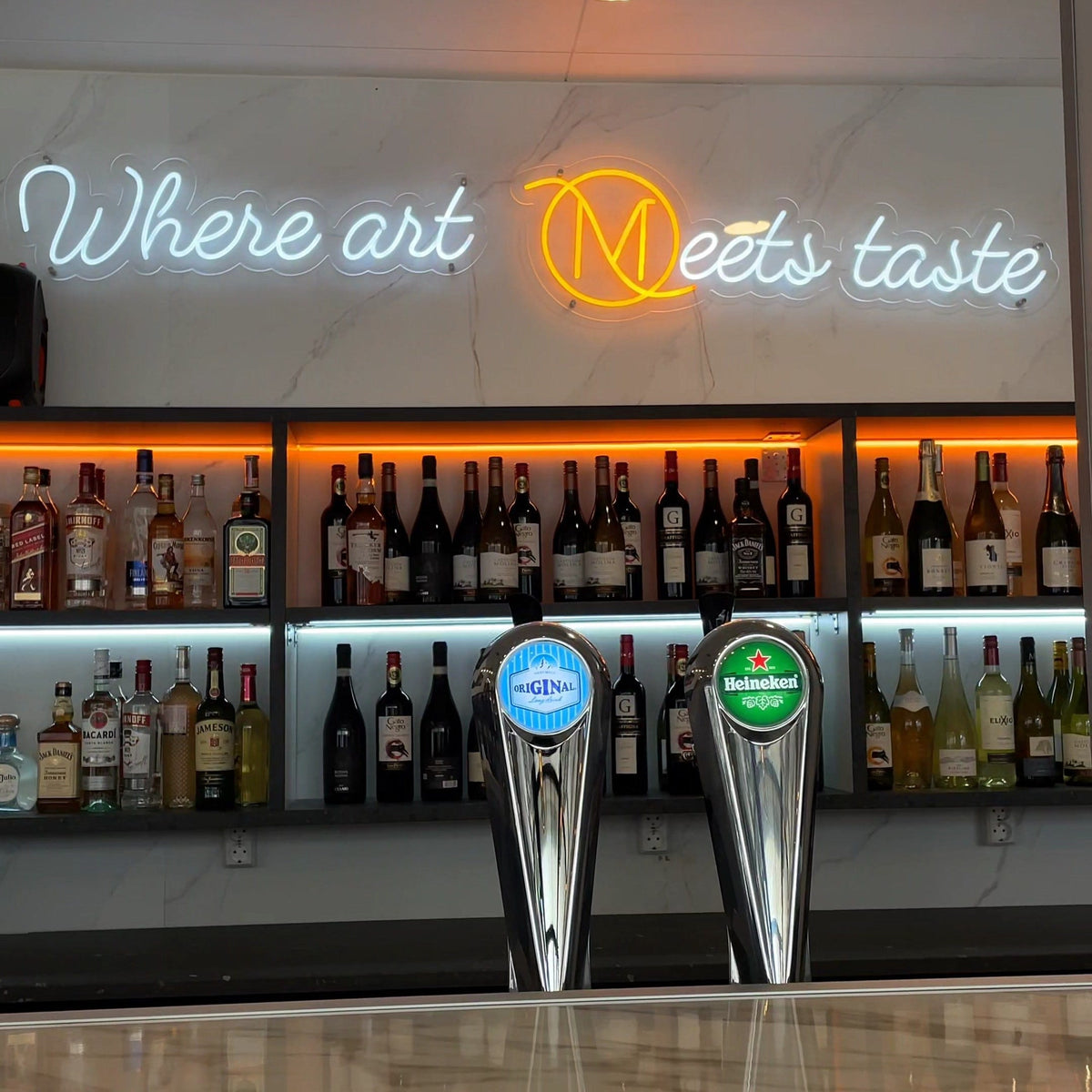 Warm-white WHERE ART MEETS TASTE LED neon installed above the Madez Lounge bar.
