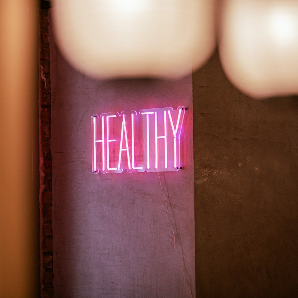 Pink vegan options LED neon sign on a wall inside Ichigo Budapest fusion restaurant.