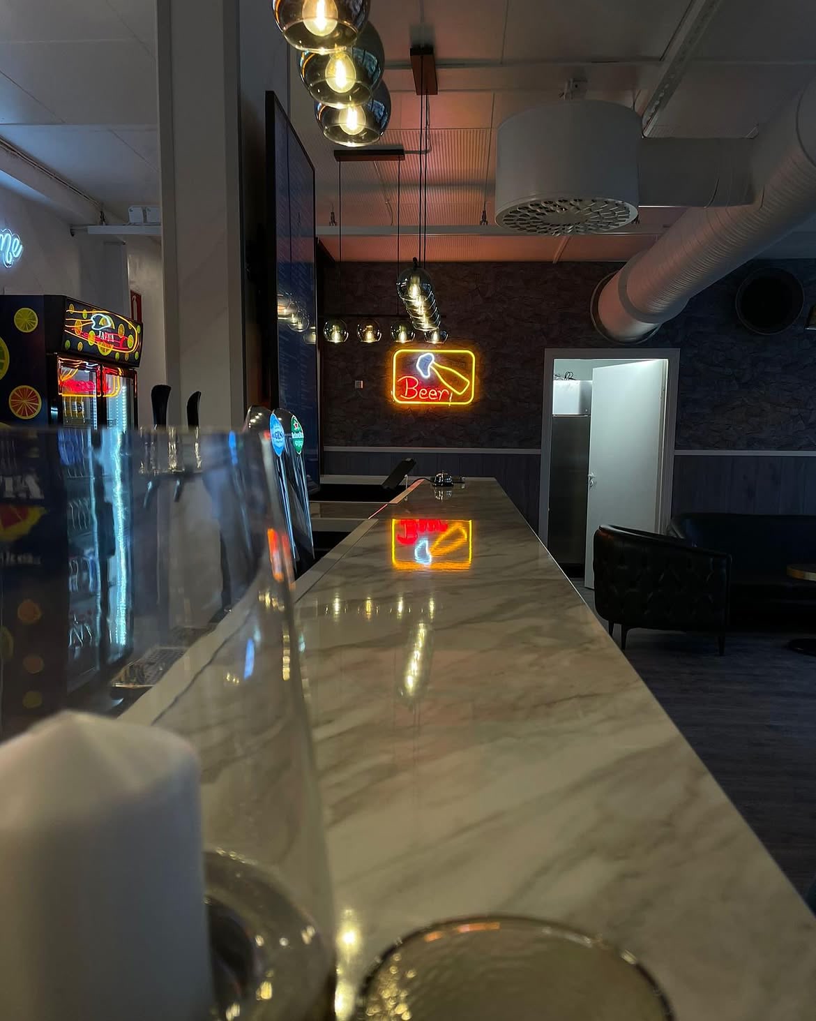 Warm-white WHERE ART MEETS TASTE LED neon installed above the Madez Lounge bar.