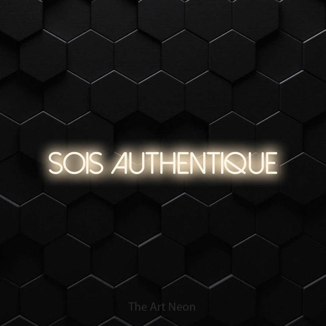 “Sois authentique” LED neon sign in warm white, with thin sans-serif lettering, shown against black hexagonal wall tiles.