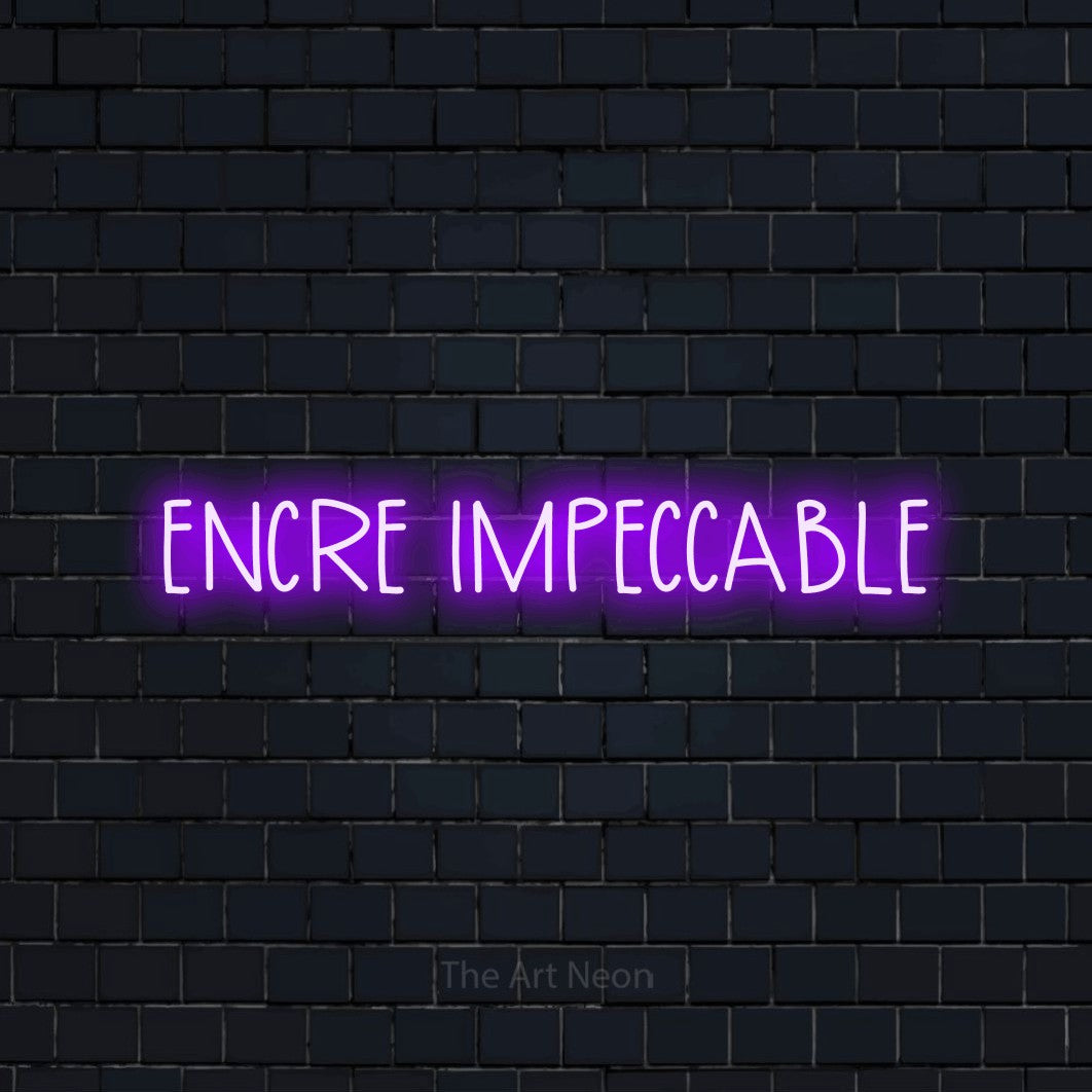 “Encre impeccable” LED neon sign in purple, with narrow hand-drawn lettering, shown against a dark navy brick wall.