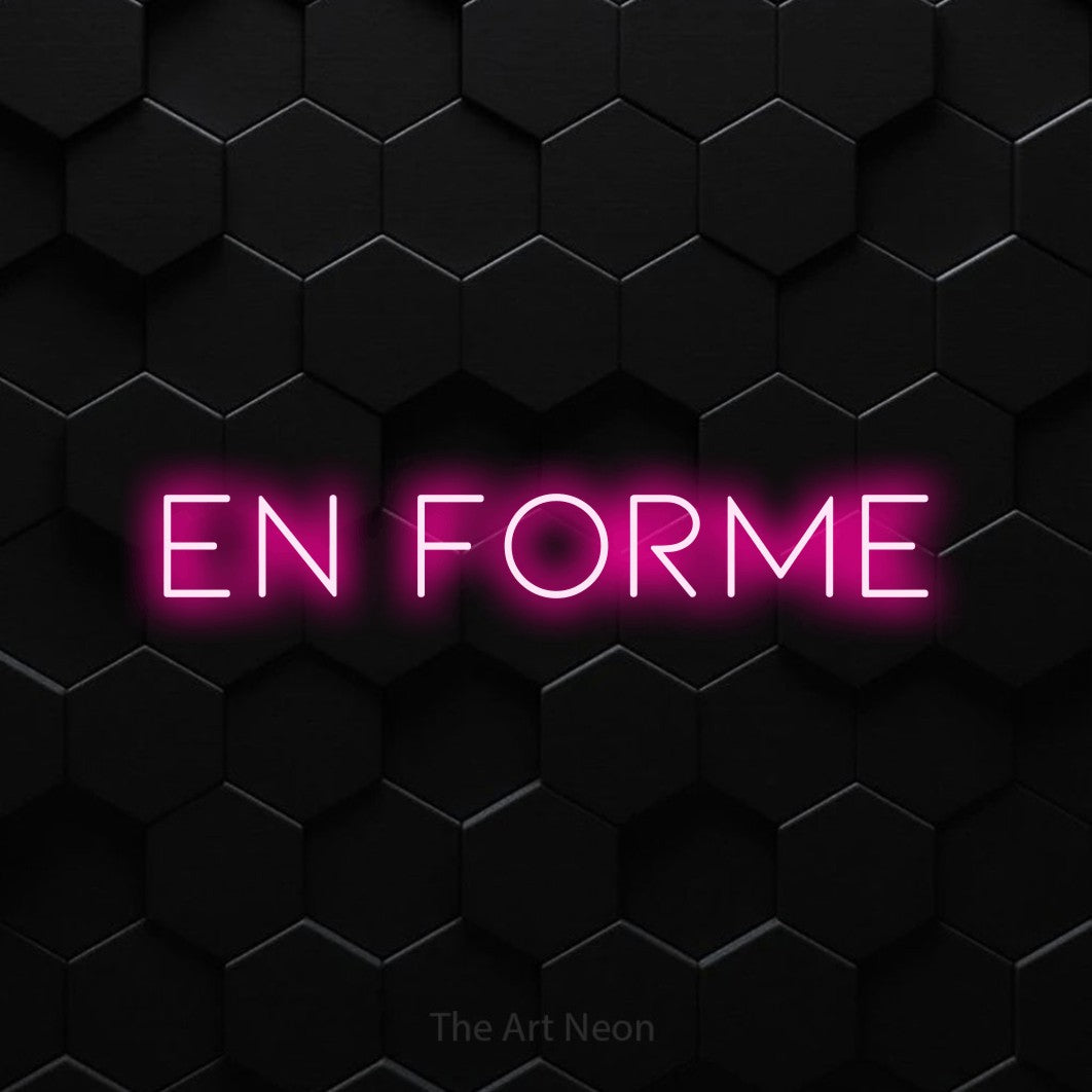 Enseigne néon LED « En forme » en rose vif, en lettres fines et espacées, présentée sur un mur de carreaux hexagonaux noirs, pour un espace d’entraînement.
