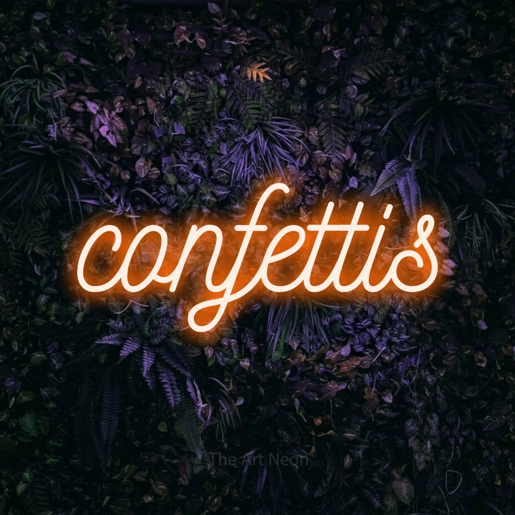“Confettis” LED neon sign in orange, with ornate cursive lettering, shown against a dark wall with purple flowers.