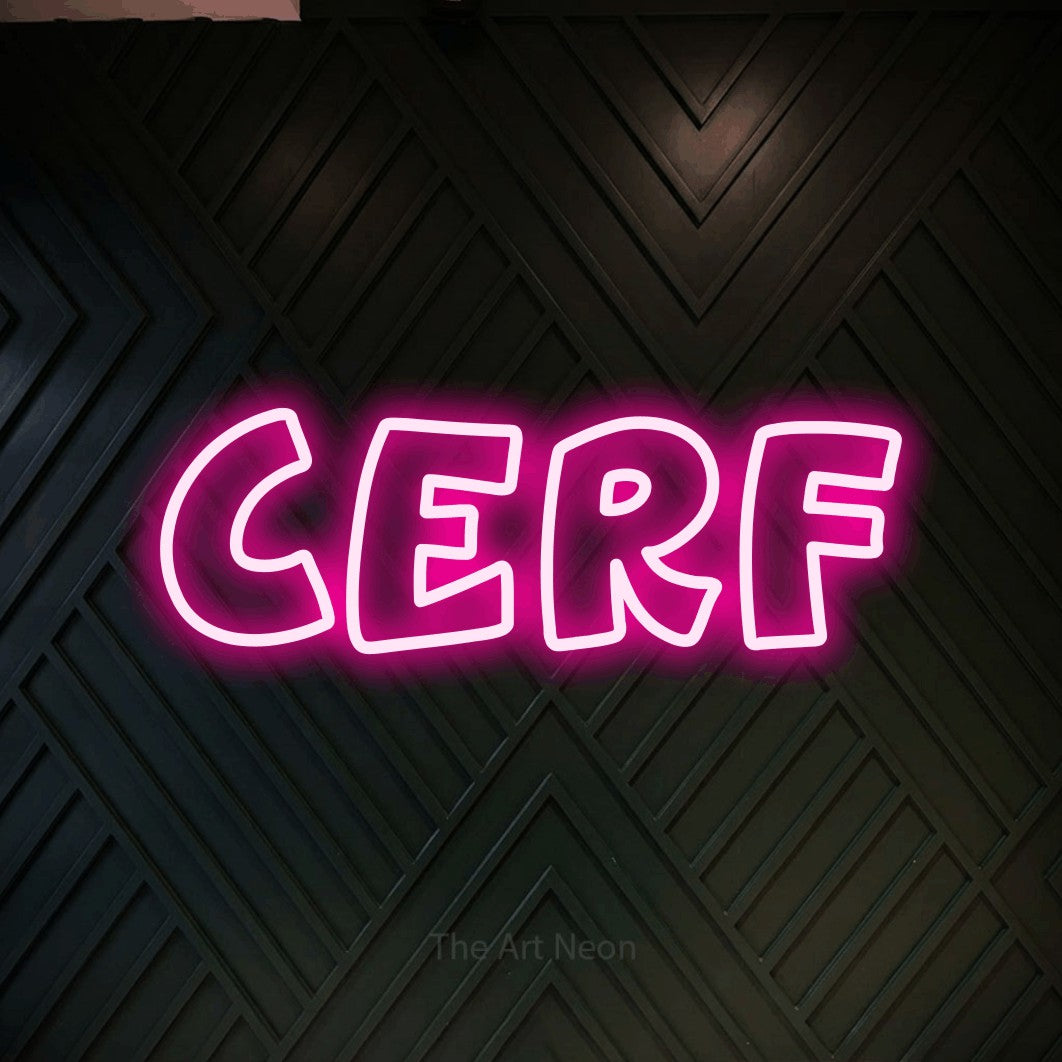 “Cerf” LED neon sign in hot pink, with rounded outline lettering, shown against a black chevron-patterned wood wall.