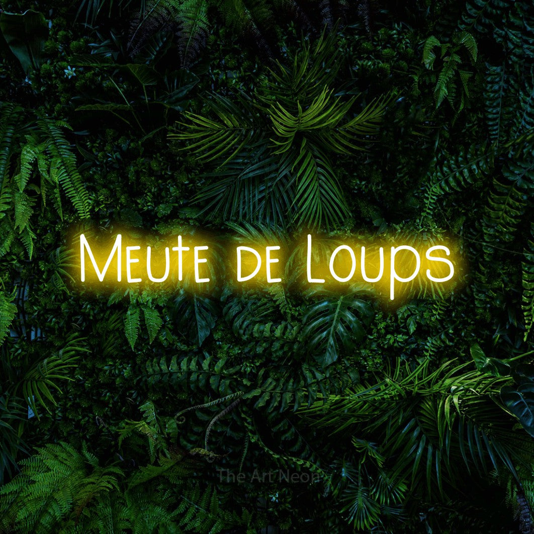 Aperçu d’une enseigne néon LED « Meute de loups » en jaune, en lettres étroites dessinées à la main, photographiée devant un feuillage tropical dense, pour un décor inspiré de la nature.