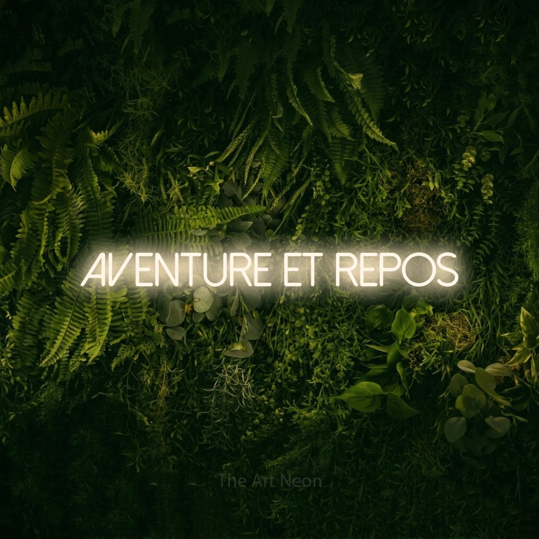 “Aventure et repos” LED neon sign in warm white, with thin sans-serif lettering, shown against a dark moss and forest backdrop.