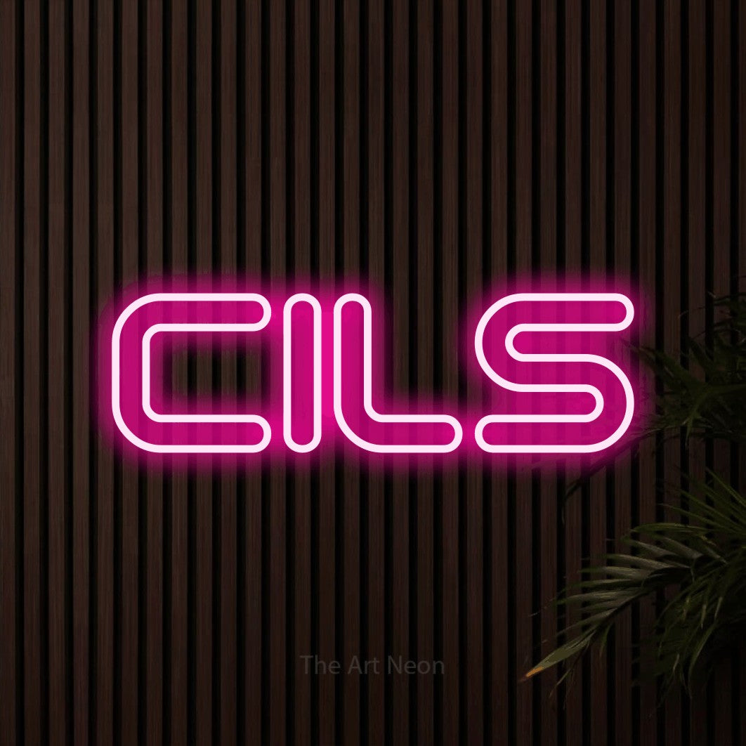 “Cils” LED neon sign in hot pink, with futuristic double-line lettering, shown against dark wooden wall slats.