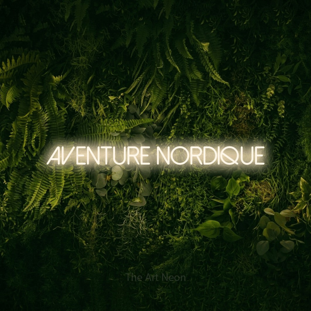 “Aventure nordique” LED neon sign in warm white, with thin sans-serif lettering, shown against a dark moss and forest backdrop.