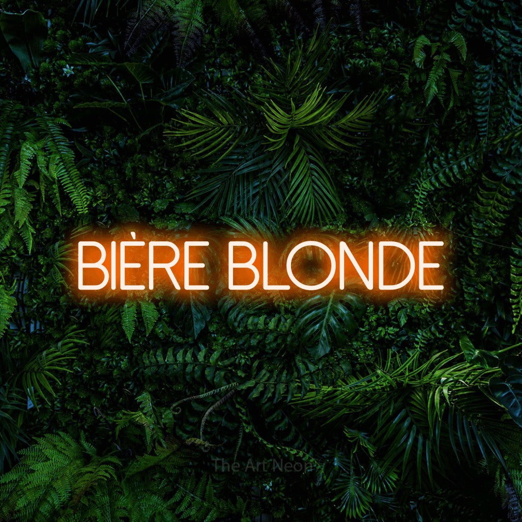 “Bière blonde” LED neon sign in orange, with thin sans-serif lettering, shown against dense tropical foliage.