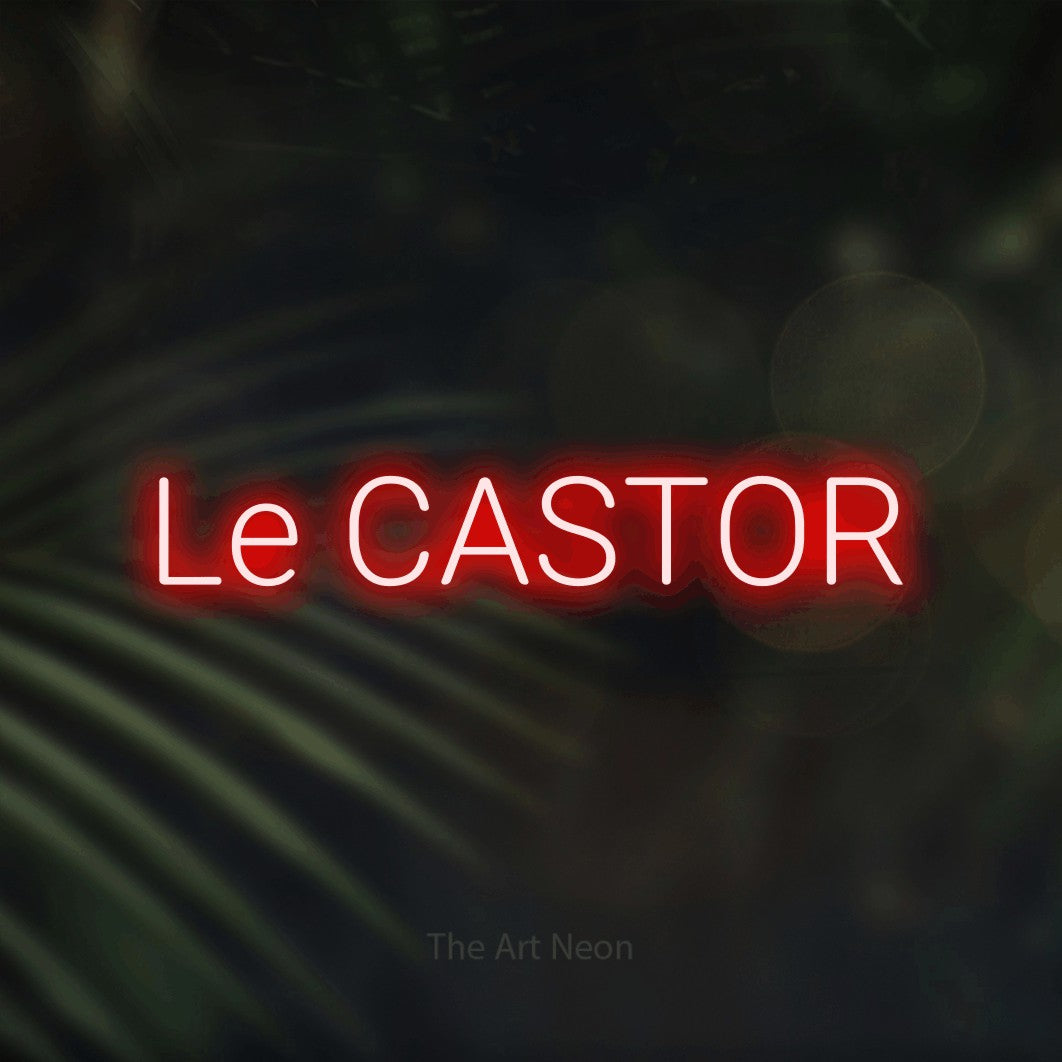 “Le castor” LED neon sign in red, with rounded sans-serif lettering, shown against a blurred palm and bokeh-light backdrop.