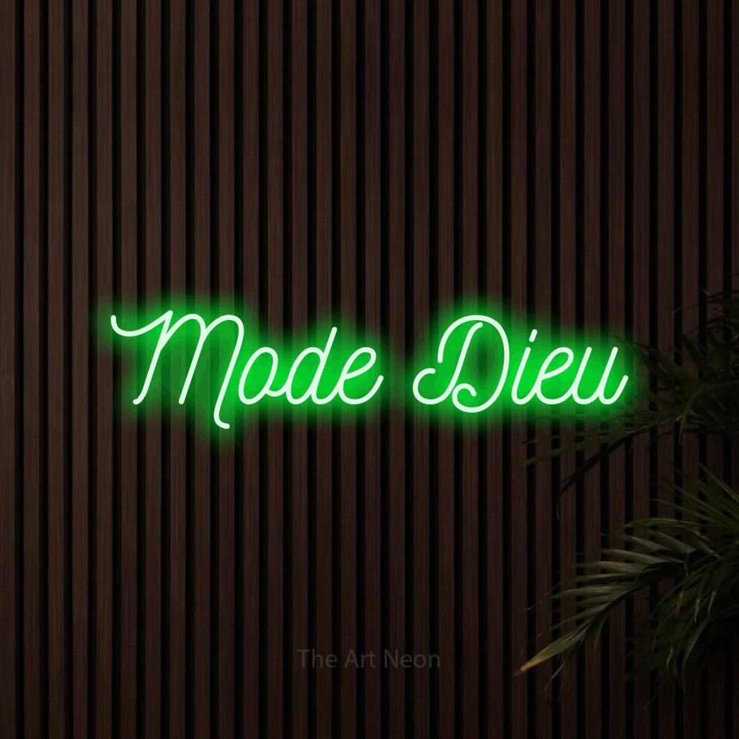 “Mode dieu” LED neon sign in green, with ornate cursive lettering, shown against dark wooden wall slats.