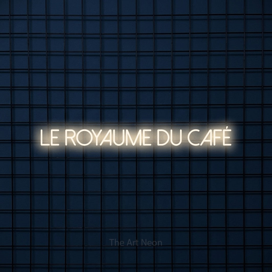 “Le royaume du café” LED neon sign in warm white, with thin sans-serif lettering, shown against a dark blue grid.