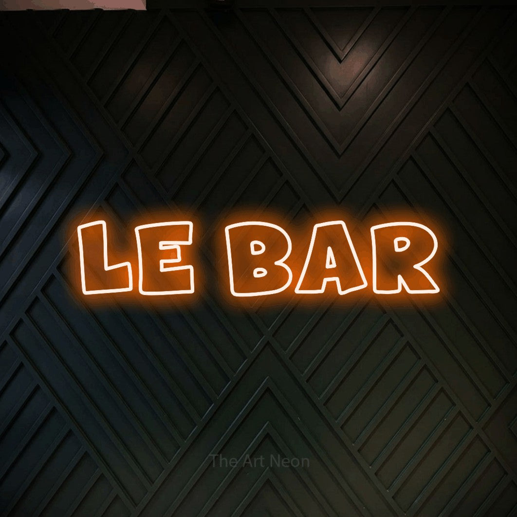 “Le bar” LED neon sign in orange, with wide lettering with irregular outlines, shown against a black chevron-patterned wood wall.