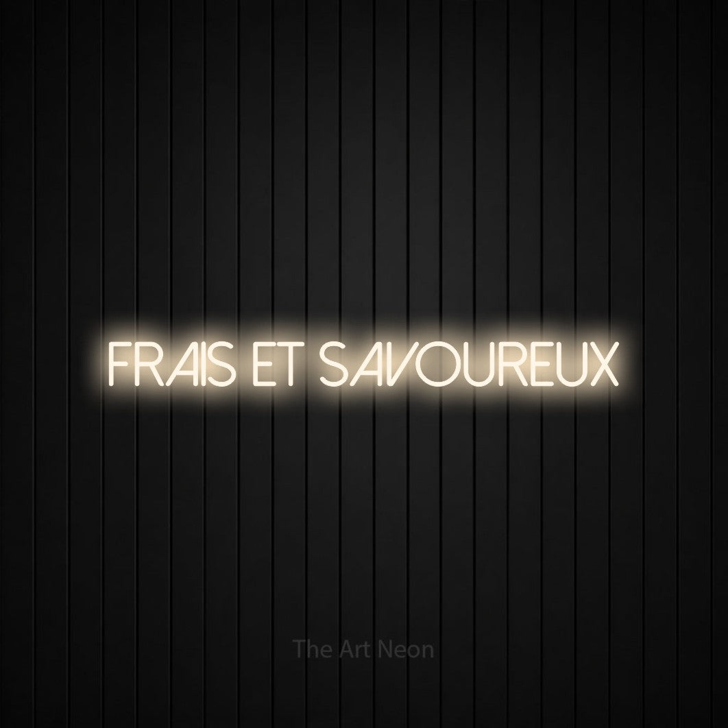 “Frais et savoureux” LED neon sign in warm white, with thin sans-serif lettering, shown against black vertical wall slats.