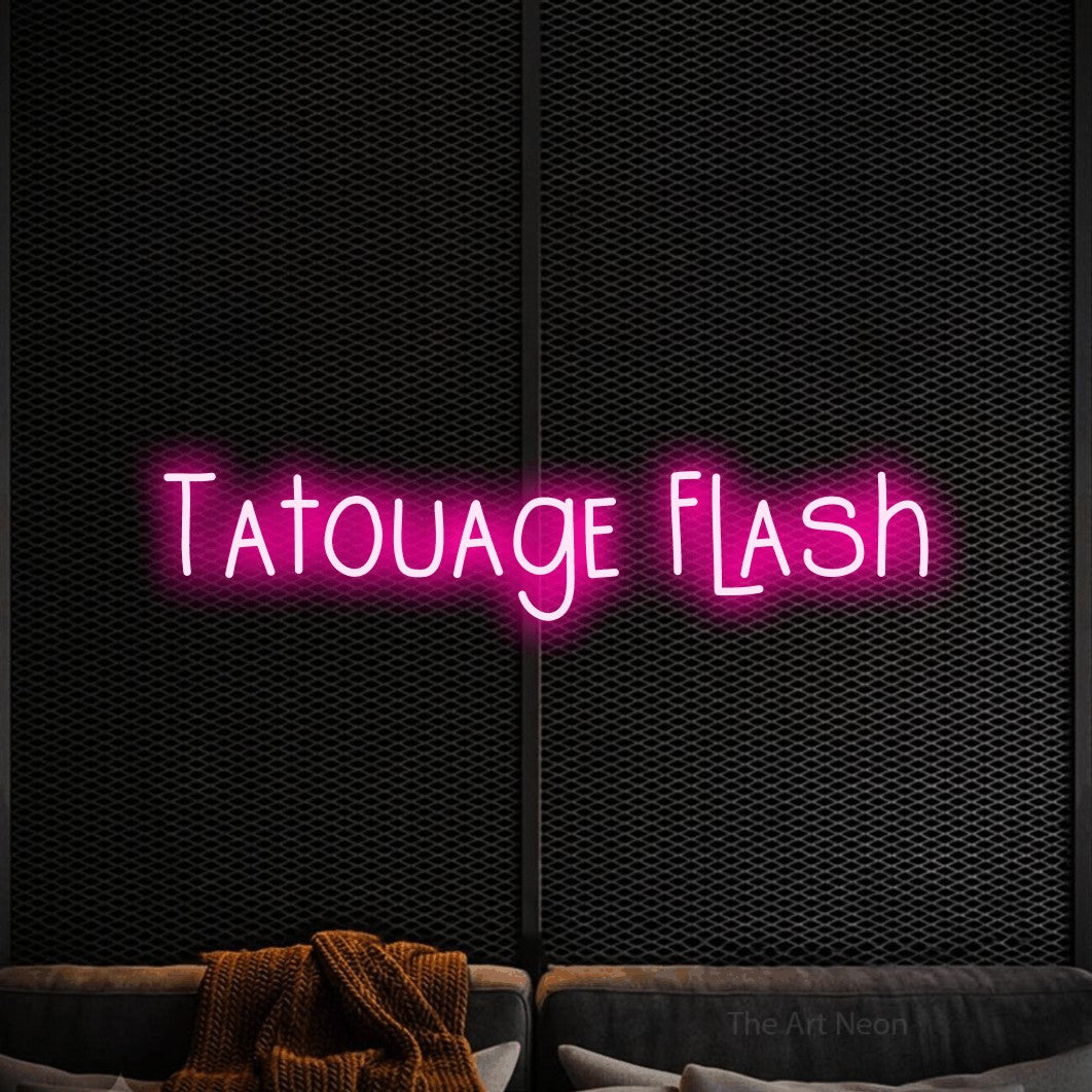 “Tatouage flash” LED neon sign in hot pink, with narrow hand-drawn lettering, shown against a modern dark-toned seating area.