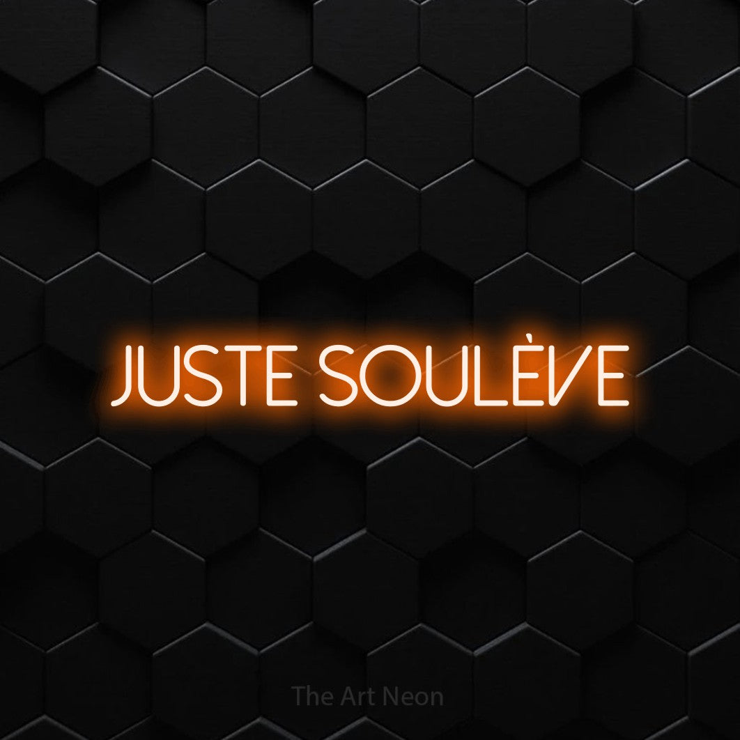 Décoration murale en néon LED « Juste soulève » en orange, en lettres fines sans empattement, installée sur un mur de carreaux hexagonaux noirs, pour un espace d’entraînement.