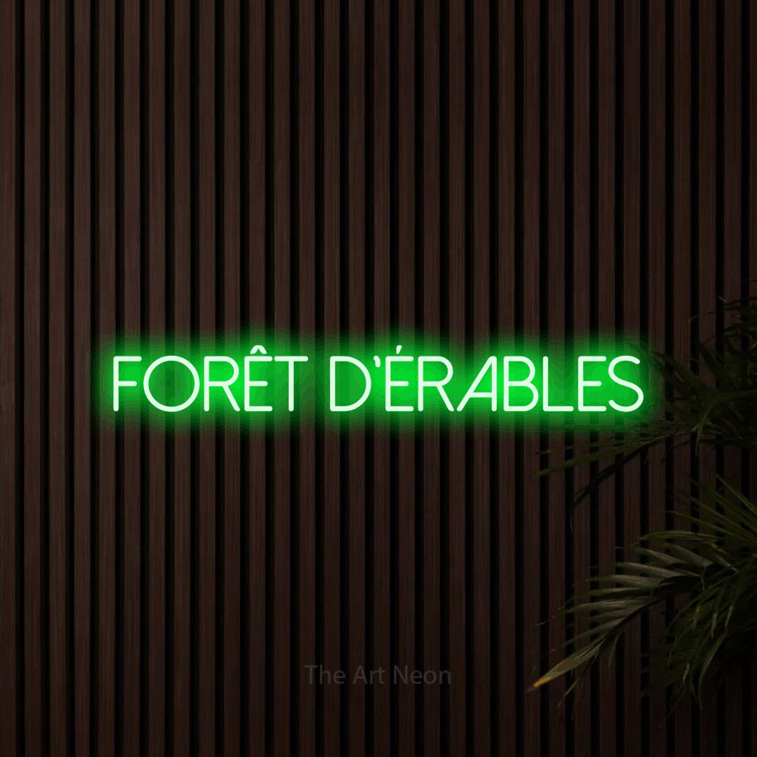 “Forêt d'érables” LED neon sign in green, with thin sans-serif lettering, shown against dark wooden wall slats.