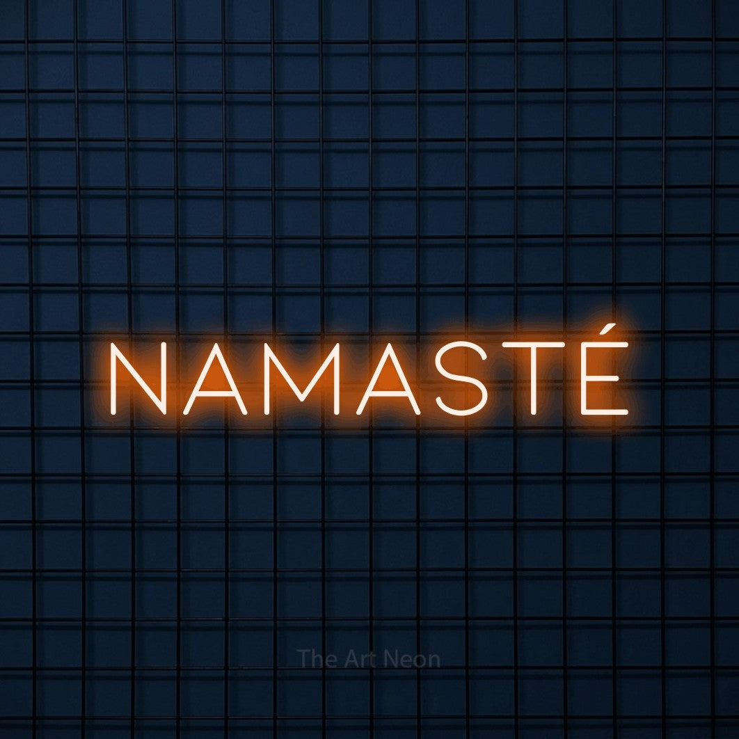 “Namasté” LED neon sign in orange, with thin, widely spaced lettering, shown against a dark blue grid.