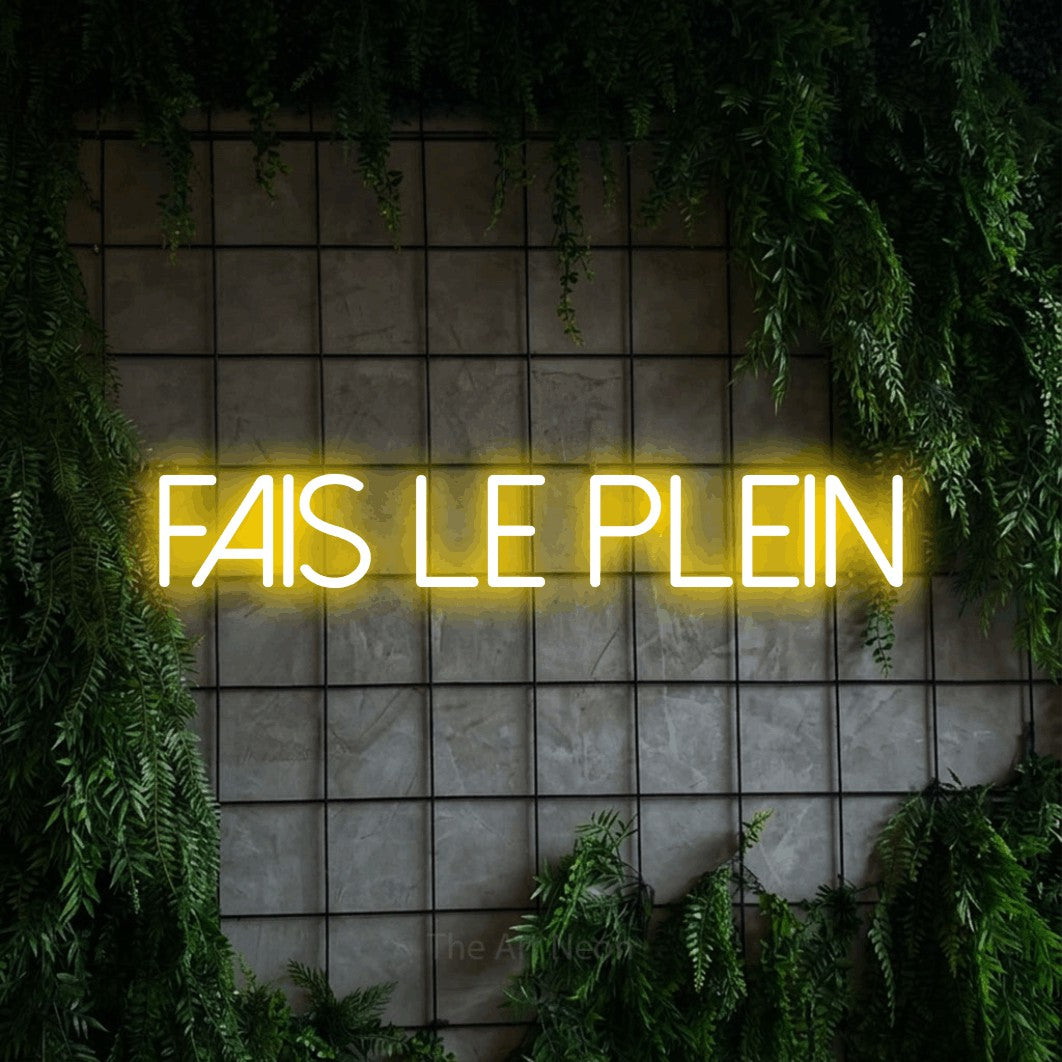 “Fais le plein” LED neon sign in yellow, with thin sans-serif lettering, shown against an ivy-covered concrete grid.