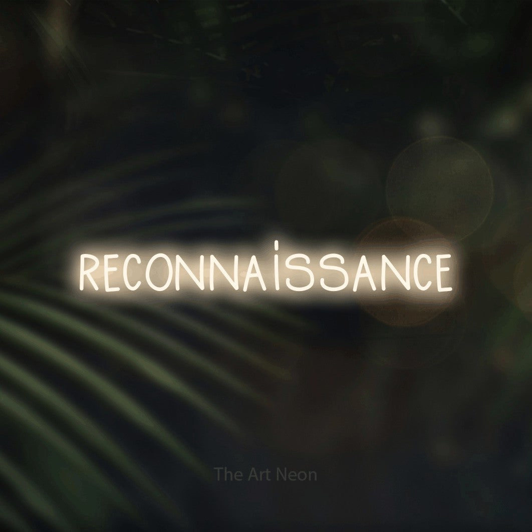 “Reconnaissance” LED neon sign in warm white, with narrow hand-drawn lettering, shown against a blurred palm and bokeh-light backdrop.