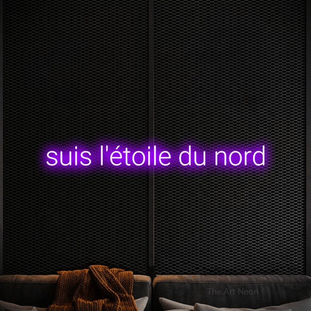 “Suis l'étoile du nord” LED neon sign in purple, with rounded sans-serif lettering, shown against a modern dark-toned seating area.