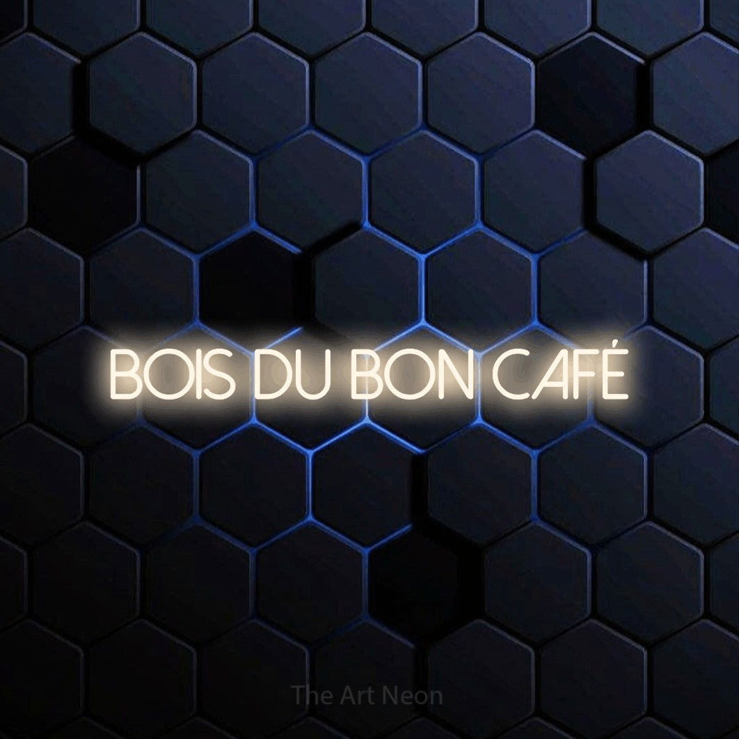 “Bois du bon café” LED neon sign in warm white, with thin sans-serif lettering, shown against a dark blue honeycomb pattern.