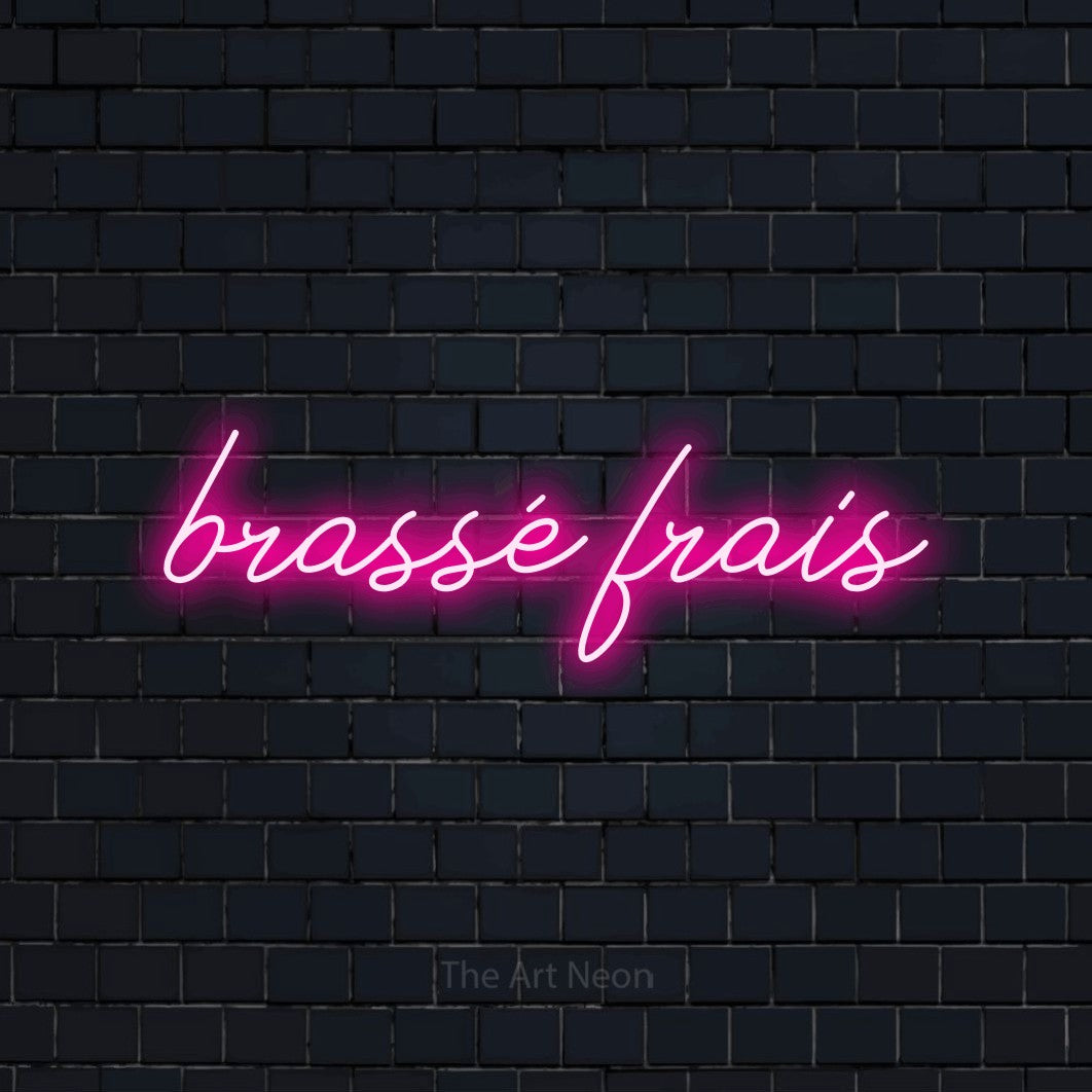 Aperçu d’une enseigne néon LED « Brassé frais » en rose vif, en lettrage cursif, photographiée sur un mur de briques bleu marine foncé, pour une microbrasserie.