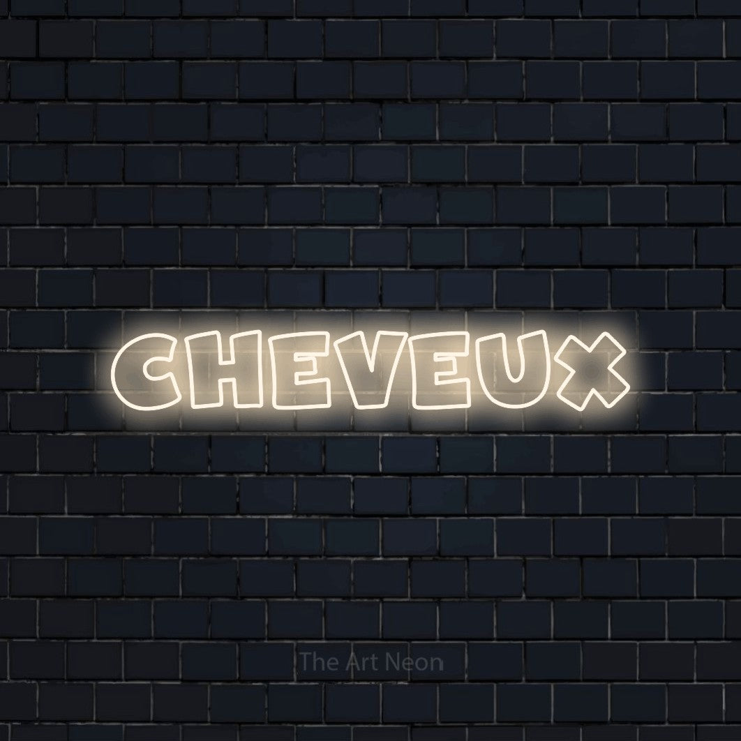 “Cheveux” LED neon sign in warm white, with wide lettering with irregular outlines, shown against a dark navy brick wall.