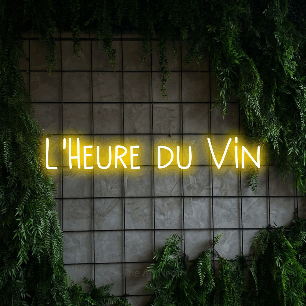 Composition en néon LED « L'heure du vin » en jaune, en lettres étroites dessinées à la main, mise en valeur sur une grille de béton couverte de lierre, pour une cuisine.