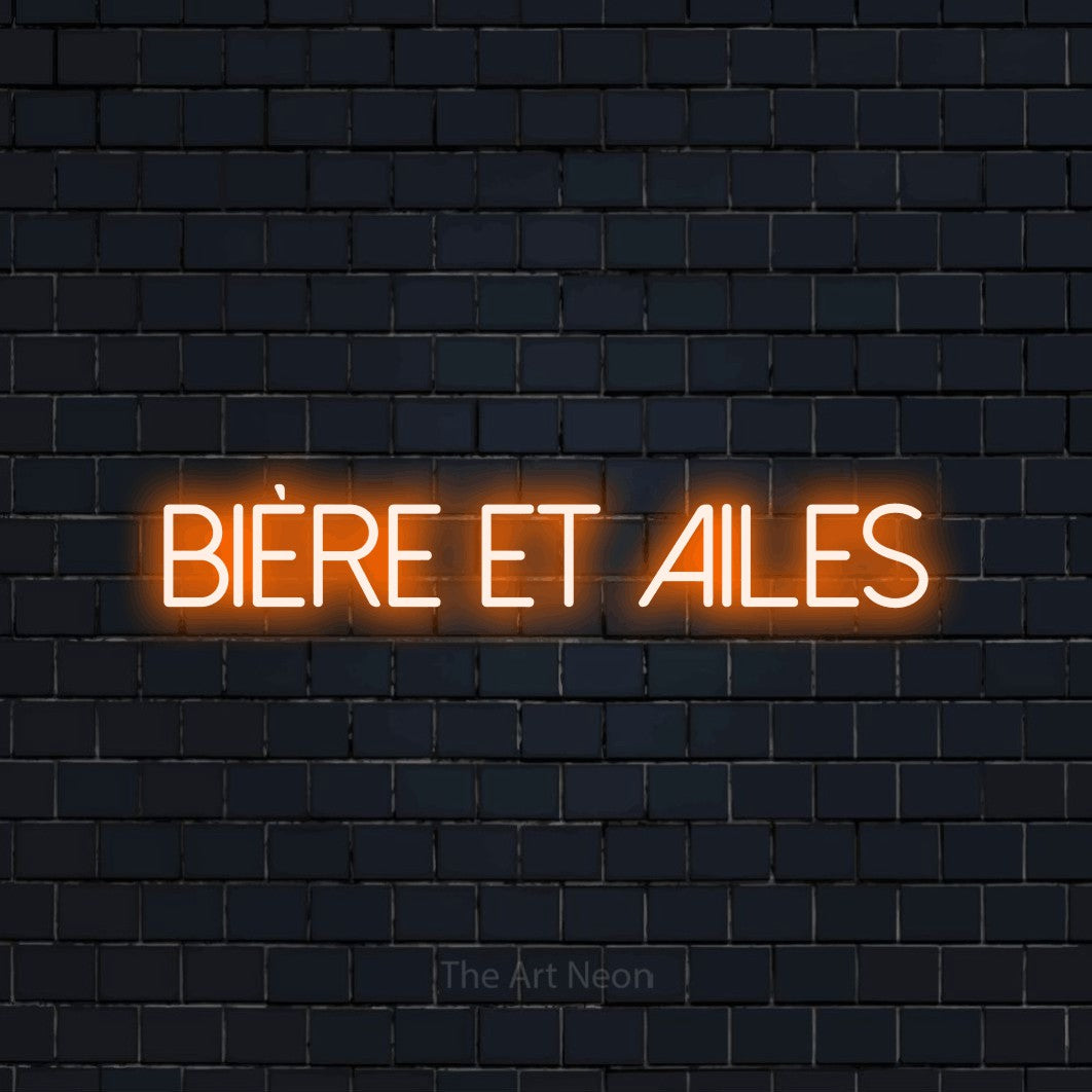 Aperçu d’une enseigne néon LED « Bière et ailes » en orange, en lettres fines sans empattement, photographiée sur un mur de briques bleu marine foncé, pour un bar ou un pub.
