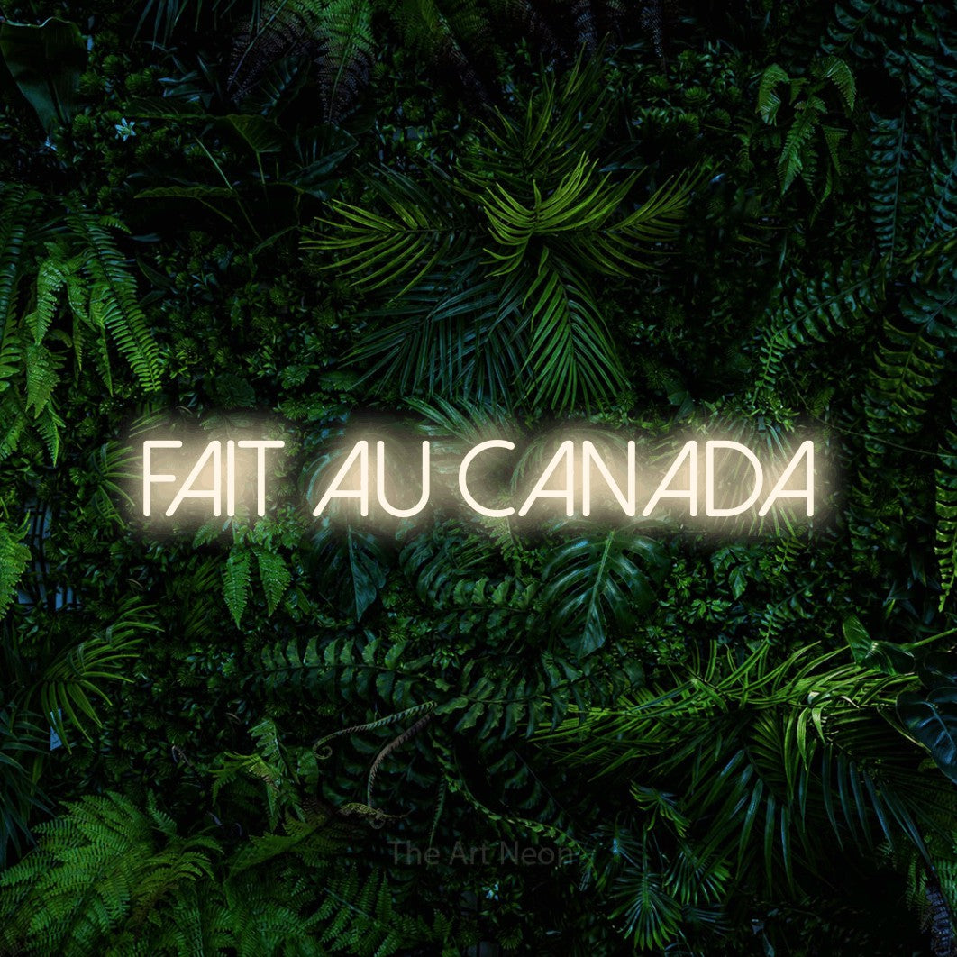 Néon LED « Fait au Canada » en blanc chaud, en lettres fines sans empattement, mis en scène devant un feuillage tropical dense, pour un décor canadien.