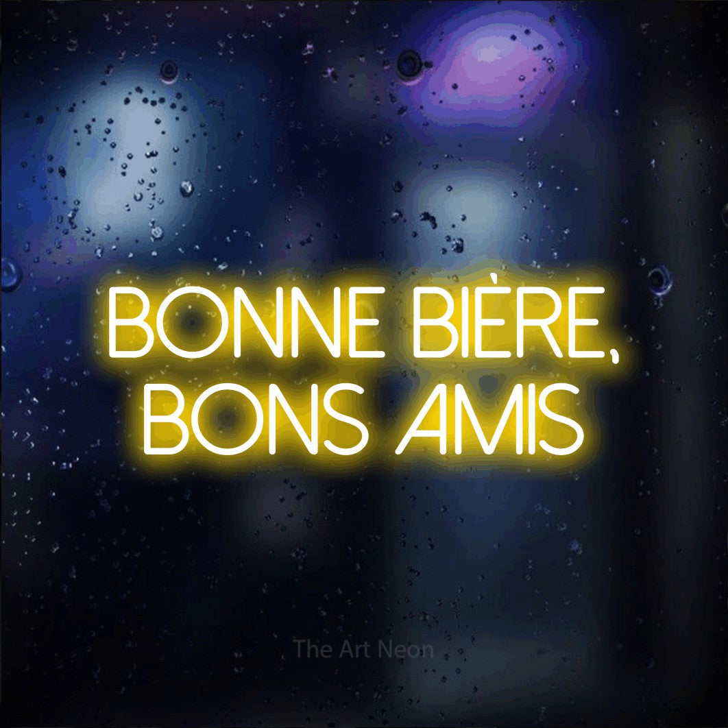 “Bonne bière, bons amis” LED neon sign in yellow, with thin sans-serif lettering across 2 lines, shown against glass with blue and purple reflections.