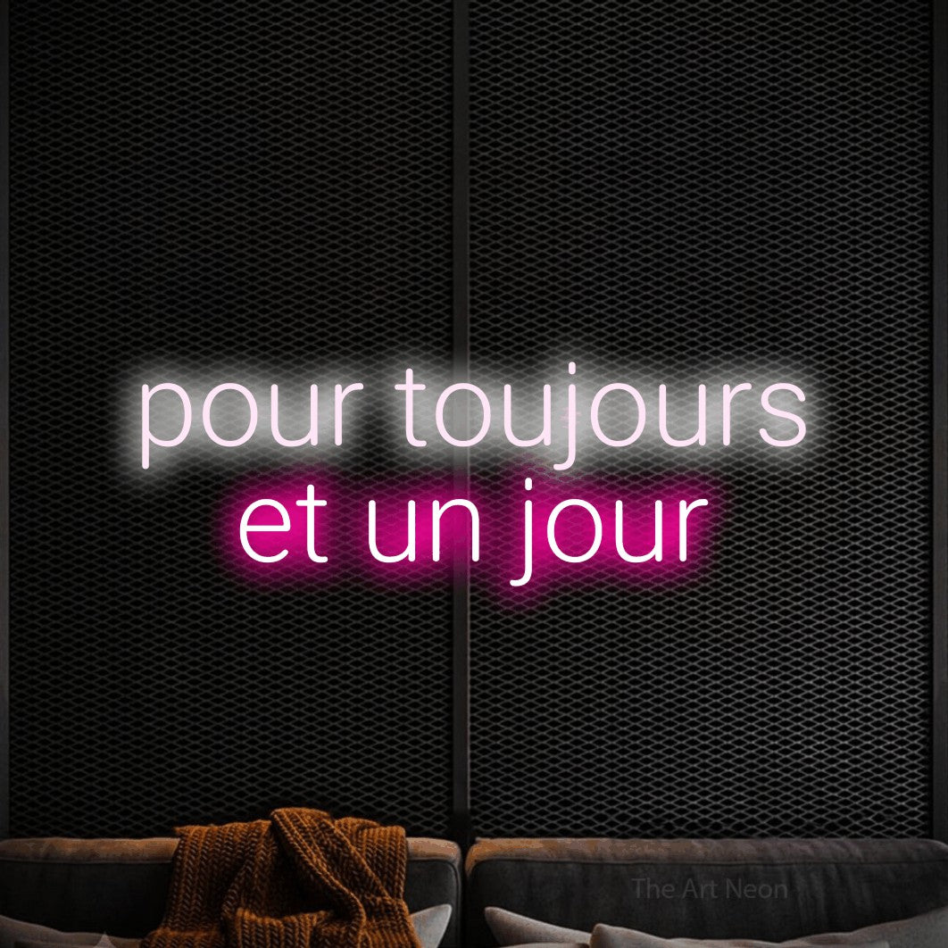 “Pour toujours et un jour” LED neon sign in cool white on the upper line and hot pink on the lower line, with rounded sans-serif lettering across 2 lines, shown against a modern dark-toned seating area.