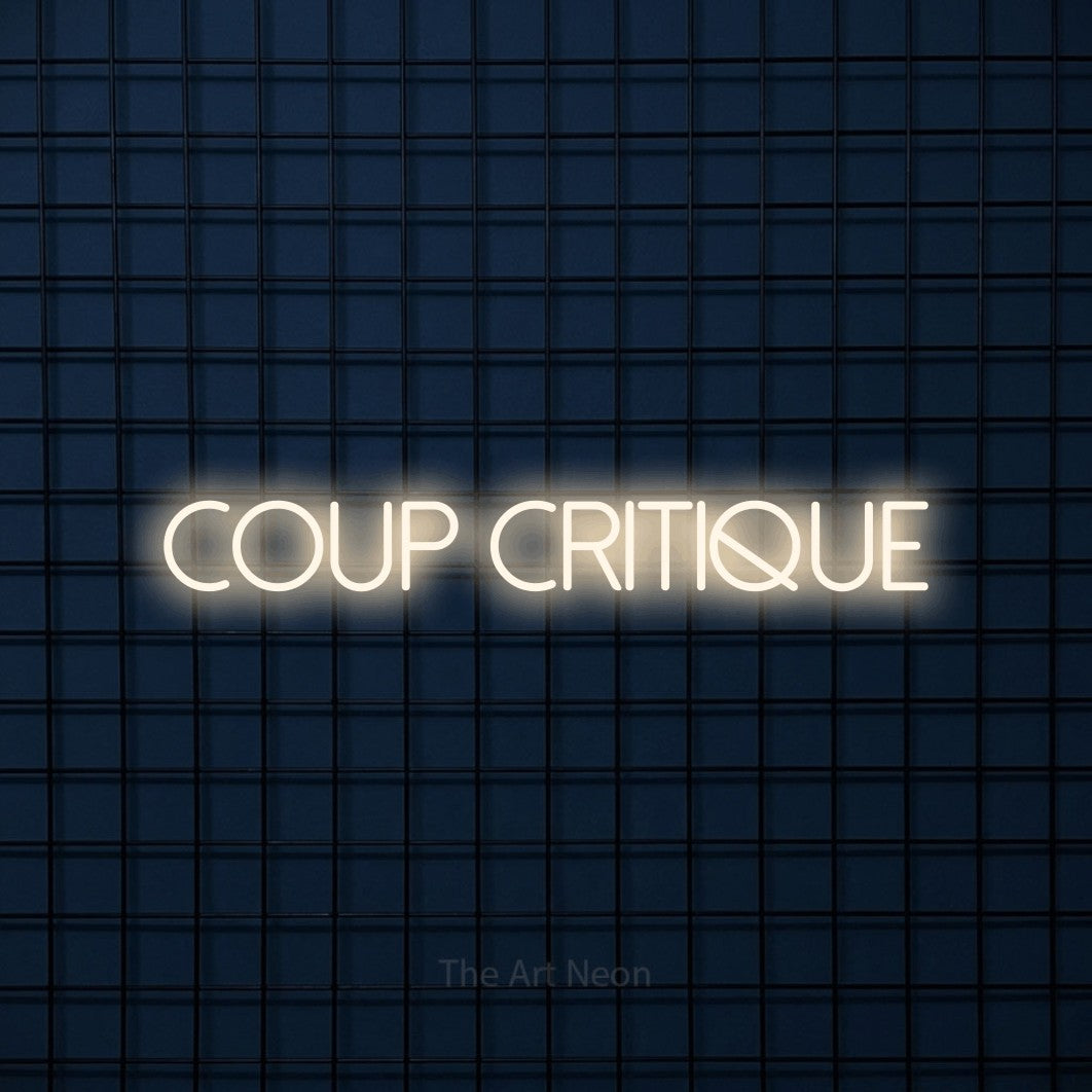 “Coup critique” LED neon sign in warm white, with thin sans-serif lettering, shown against a dark blue grid.