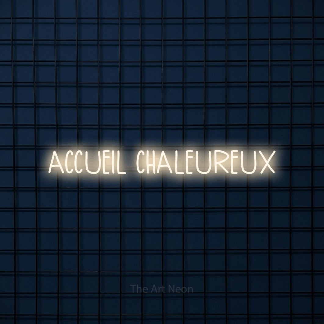“Accueil chaleureux” LED neon sign in warm white, with narrow hand-drawn lettering, shown against a dark blue grid.