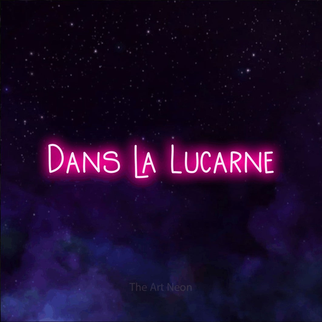 “Dans la lucarne” LED neon sign in hot pink, with narrow hand-drawn lettering, shown against a purple galaxy backdrop.