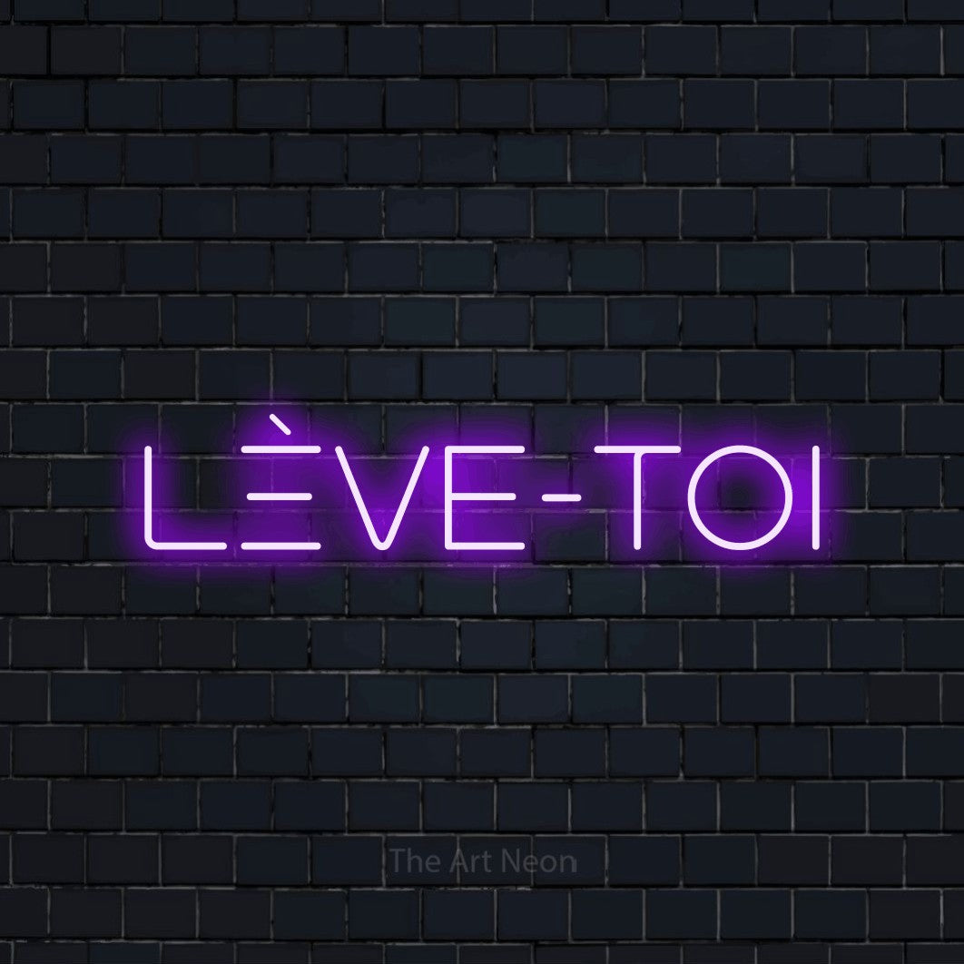 “Lève-toi” LED neon sign in purple, with stylised geometric lettering, shown against a dark navy brick wall.