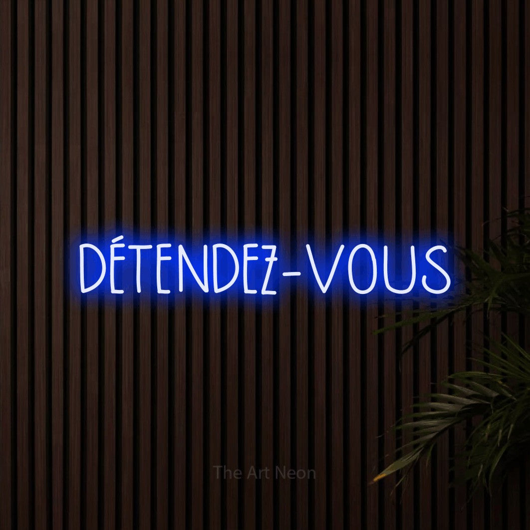 Enseigne néon LED « Détendez-vous » en bleu, en lettres étroites dessinées à la main, présentée sur un mur de lattes en bois foncé, pour un hôtel.