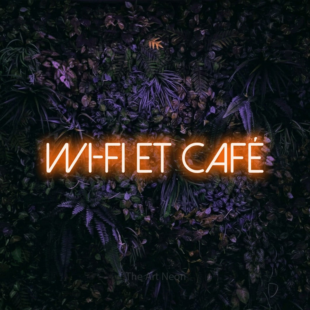 Néon LED « Wi-Fi et café » en orange, en lettres fines sans empattement, mis en scène sur un mur sombre aux fleurs violettes, pour un café.