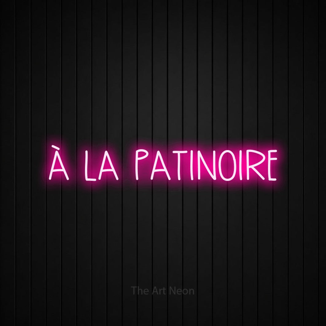 “À la patinoire” LED neon sign in hot pink, with narrow hand-drawn lettering, shown against black vertical wall slats.