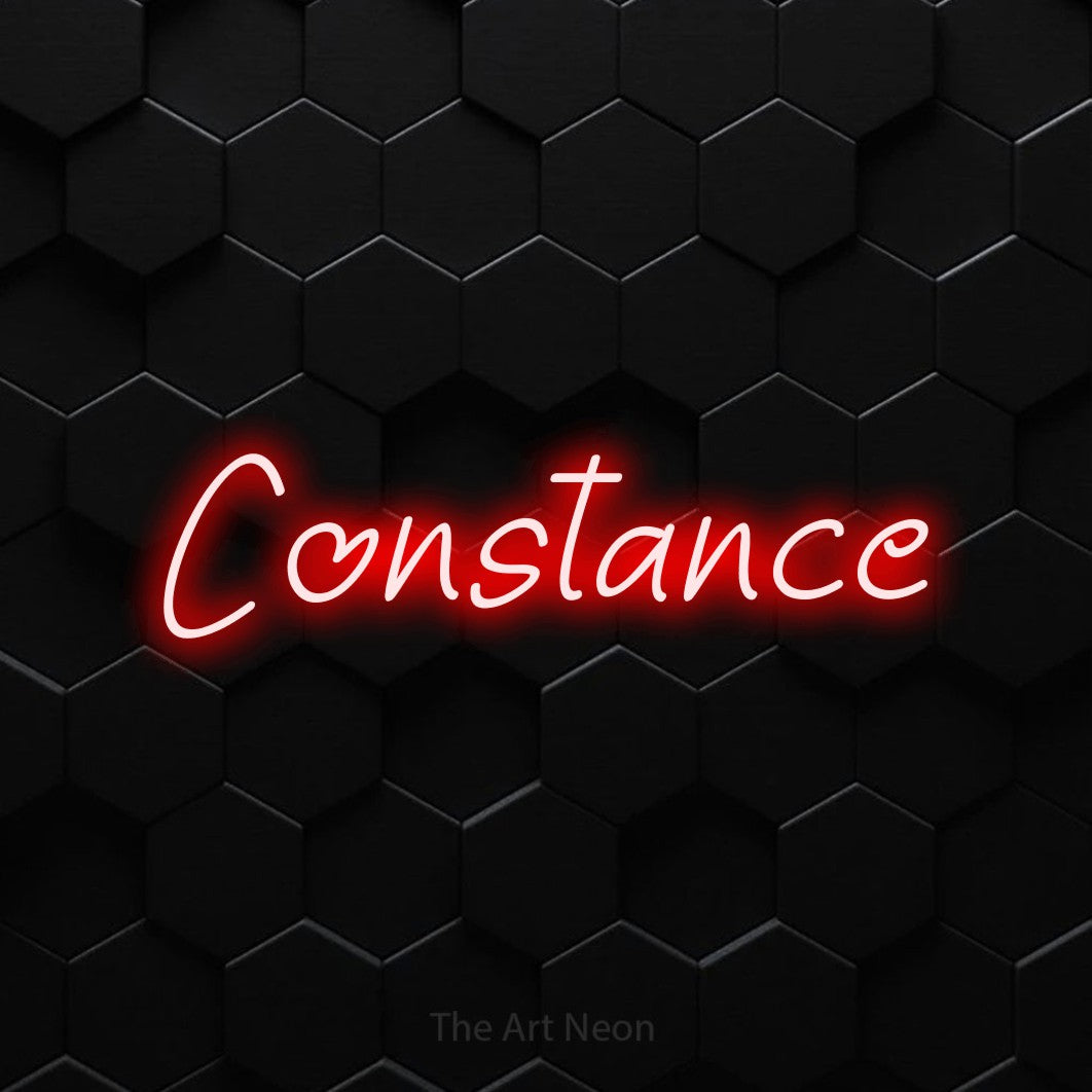 “Constance” LED neon sign in red, with slanted handwritten lettering, shown against black hexagonal wall tiles.