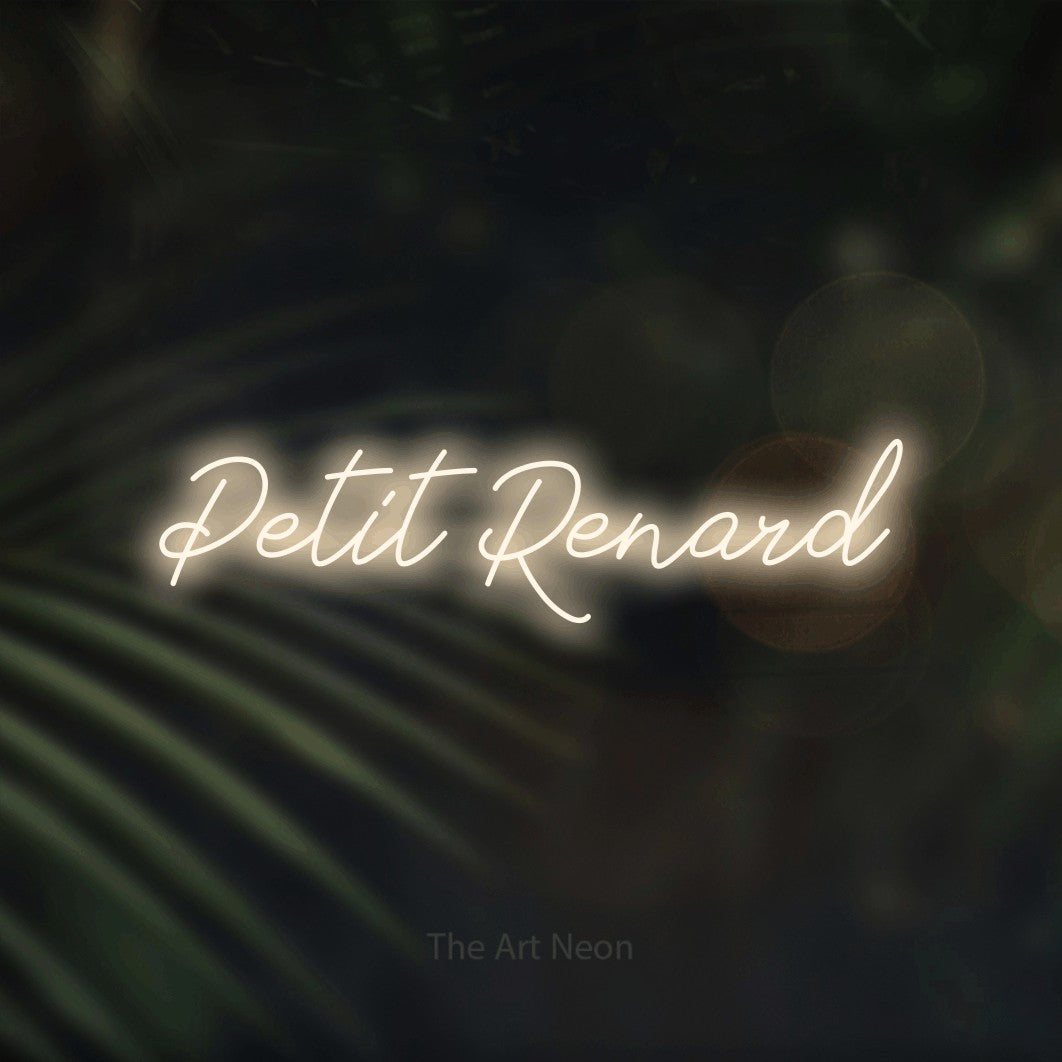Lettrage en néon LED « Petit renard » en blanc chaud, en lettrage cursif, présenté sur un fond flou de palmiers et de lumières bokeh, pour une chambre d’enfant.