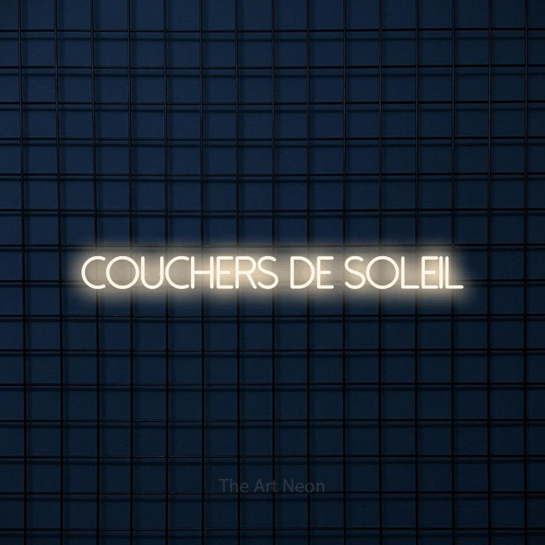 “Couchers de soleil” LED neon sign in warm white, with thin sans-serif lettering, shown against a dark blue grid.