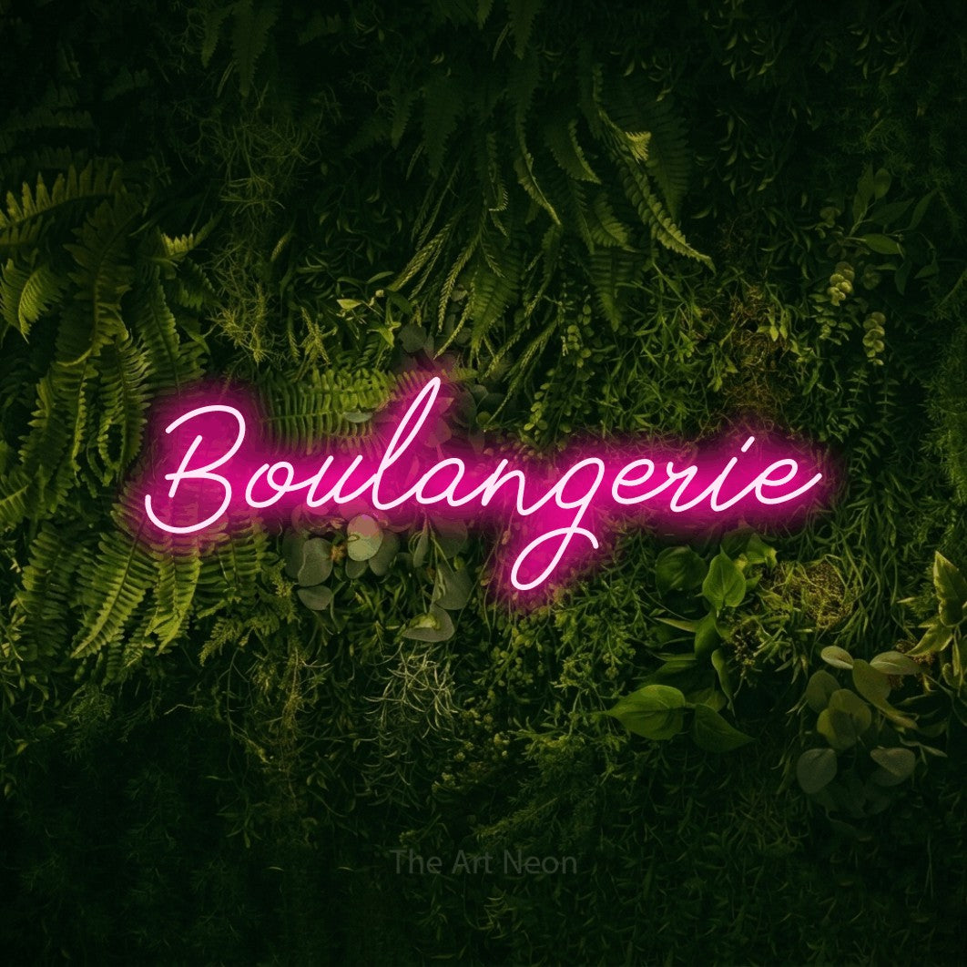 “Boulangerie” LED neon sign in hot pink, with cursive lettering, shown against a dark moss and forest backdrop.