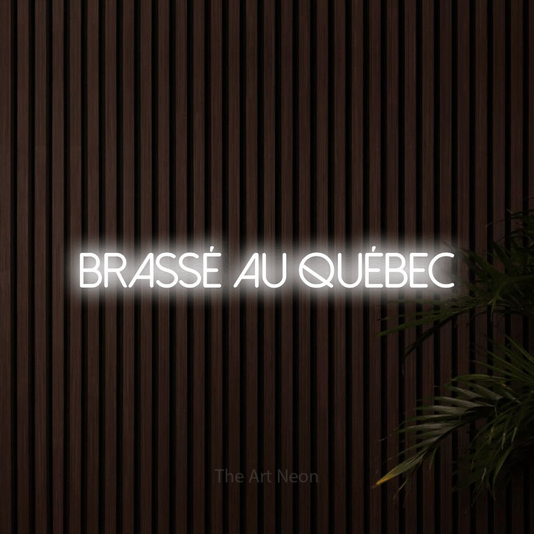 “Brassé au Québec” LED neon sign in cool white, with thin sans-serif lettering, shown against dark wooden wall slats.