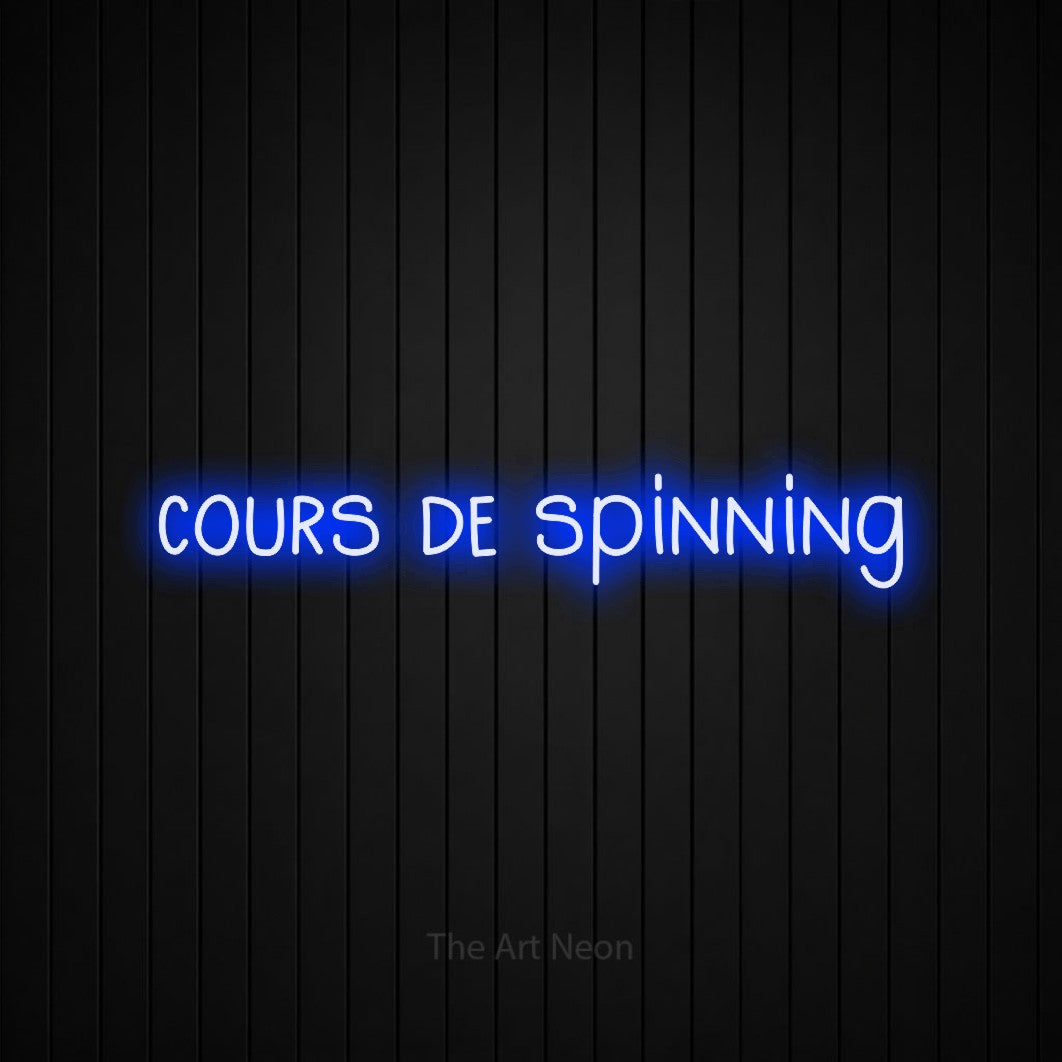 Décoration murale en néon LED « Cours de spinning » en bleu, en lettres étroites dessinées à la main, installée sur un mur de lattes verticales noires, pour un espace d’entraînement.